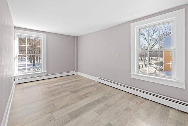 spare room with a baseboard radiator and light hardwood / wood-style floors