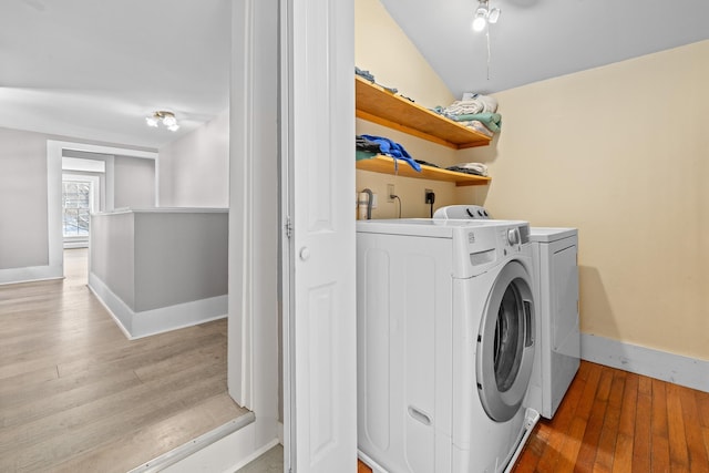 clothes washing area with light hardwood / wood-style flooring and independent washer and dryer