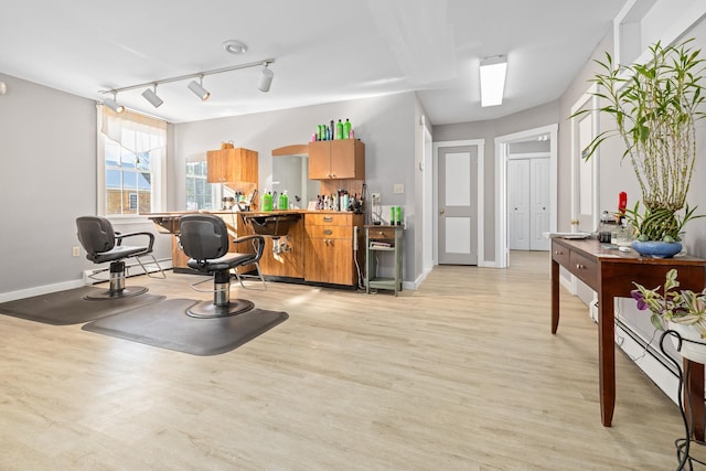 interior space featuring rail lighting and light hardwood / wood-style floors