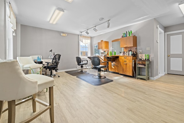 exercise area featuring light hardwood / wood-style floors and rail lighting