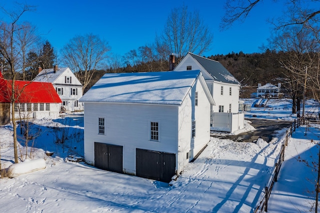 view of snowy exterior featuring a garage