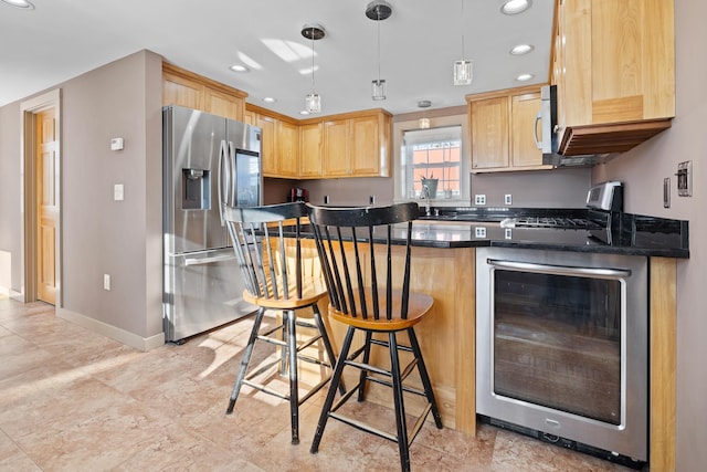 kitchen with pendant lighting, appliances with stainless steel finishes, a kitchen breakfast bar, and light brown cabinetry