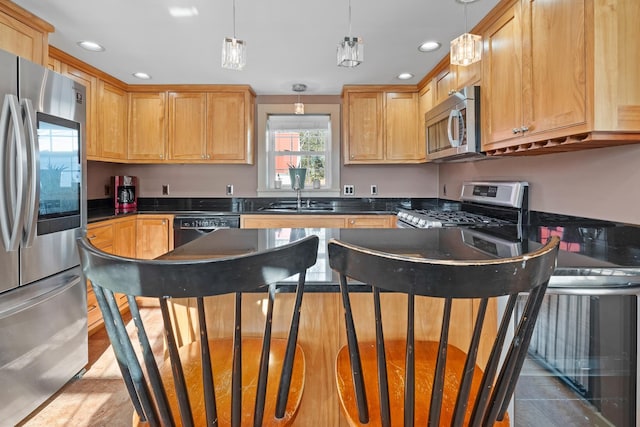 kitchen featuring sink, hanging light fixtures, a center island, and appliances with stainless steel finishes