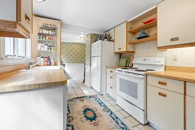 kitchen featuring white appliances, white cabinetry, open shelves, a sink, and light tile patterned flooring