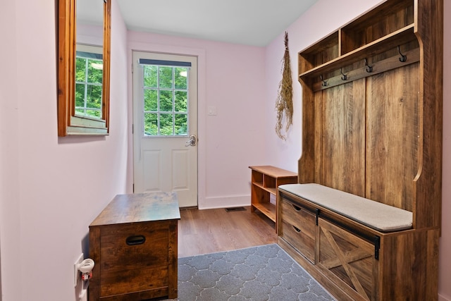 mudroom with baseboards, visible vents, and dark wood-type flooring