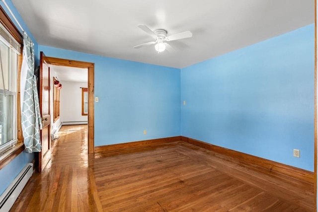 unfurnished room featuring dark hardwood / wood-style flooring, ceiling fan, and baseboard heating