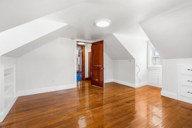 additional living space featuring hardwood / wood-style floors and vaulted ceiling