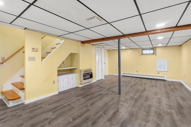 basement featuring hardwood / wood-style floors, a baseboard radiator, heating unit, and a drop ceiling