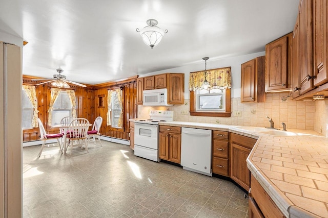 kitchen with white appliances, a healthy amount of sunlight, decorative light fixtures, and a baseboard heating unit