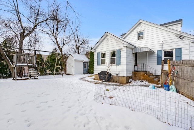 snow covered property with a shed