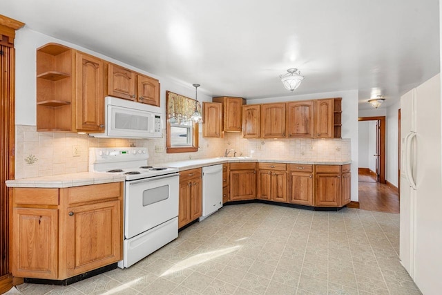 kitchen featuring sink, hanging light fixtures, white appliances, and decorative backsplash