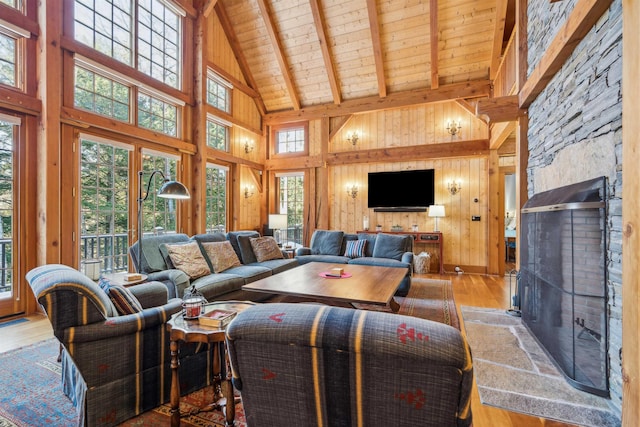 living room with a wealth of natural light, light hardwood / wood-style floors, and wood walls