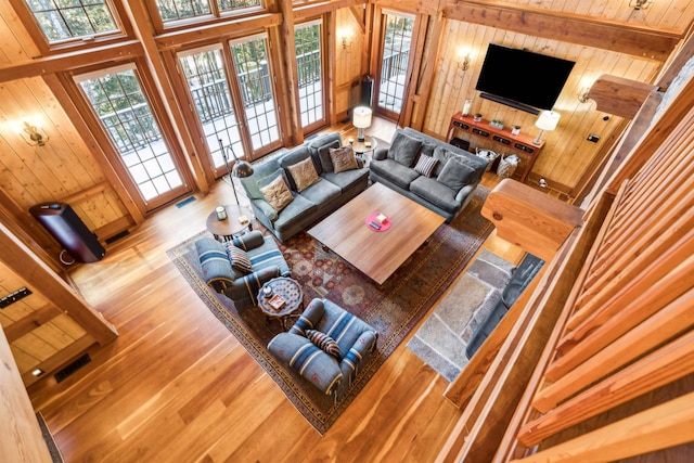 living room with hardwood / wood-style floors, a wealth of natural light, wooden ceiling, and wood walls