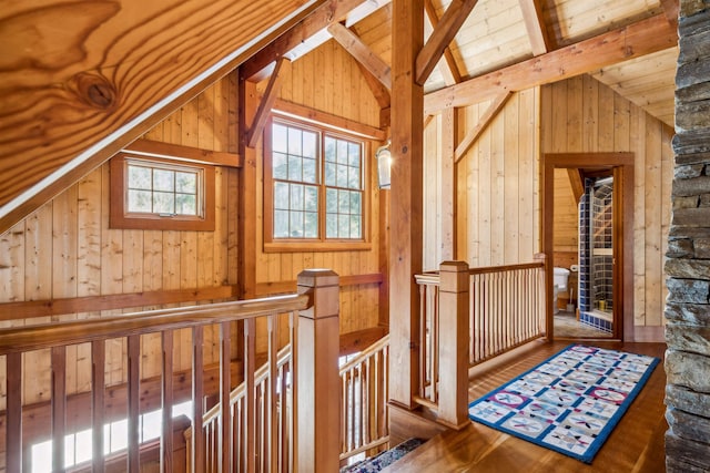 bonus room featuring hardwood / wood-style floors, wood ceiling, wooden walls, and lofted ceiling with beams