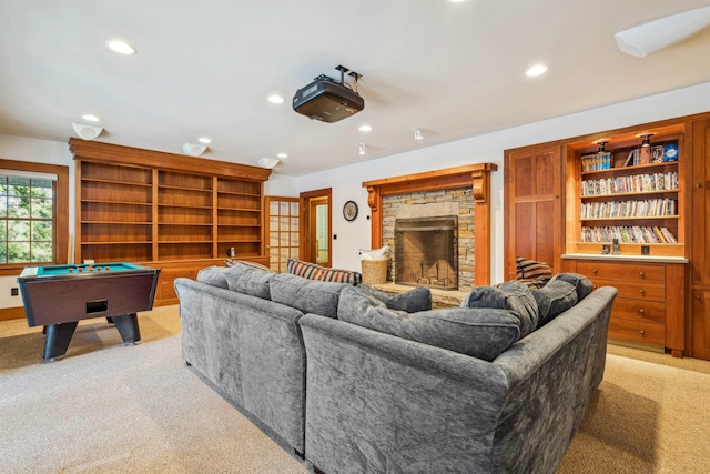 carpeted living room with pool table and a stone fireplace