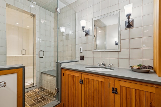 bathroom with walk in shower, vanity, tile walls, and backsplash