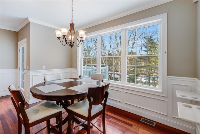 dining space with hardwood / wood-style floors, ornamental molding, and a healthy amount of sunlight