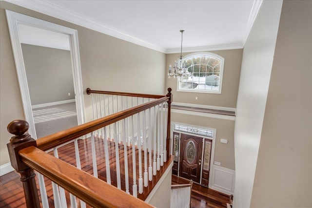 foyer with dark hardwood / wood-style flooring, a notable chandelier, and crown molding