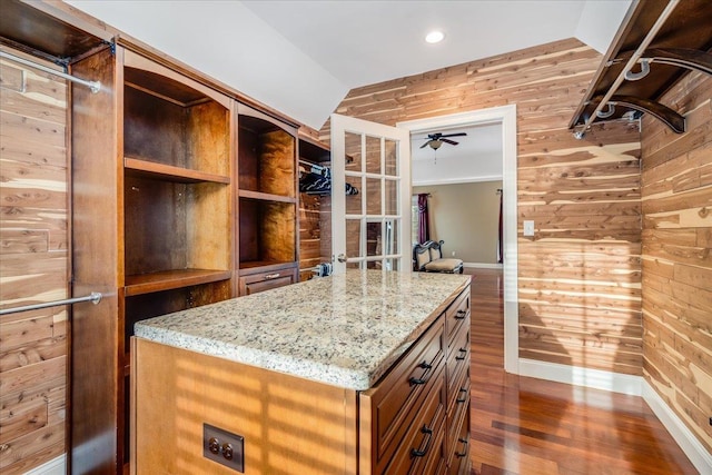 walk in closet with dark hardwood / wood-style flooring, vaulted ceiling, and ceiling fan