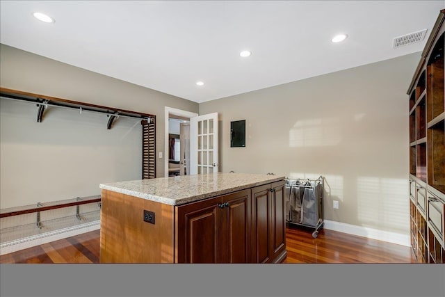 kitchen featuring french doors, light stone countertops, dark hardwood / wood-style floors, and a kitchen island