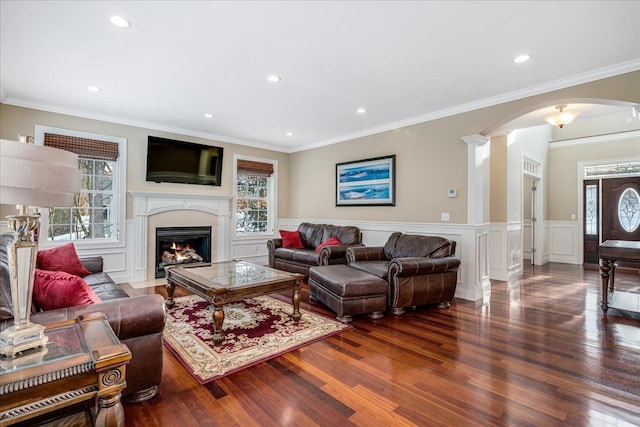 living room featuring hardwood / wood-style floors, ornamental molding, and ornate columns