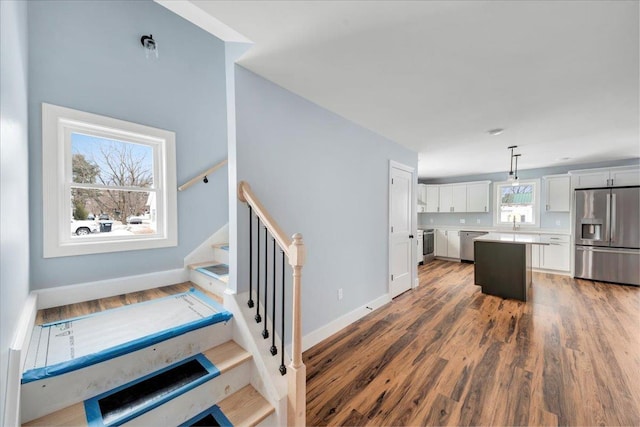 stairway featuring baseboards and wood finished floors