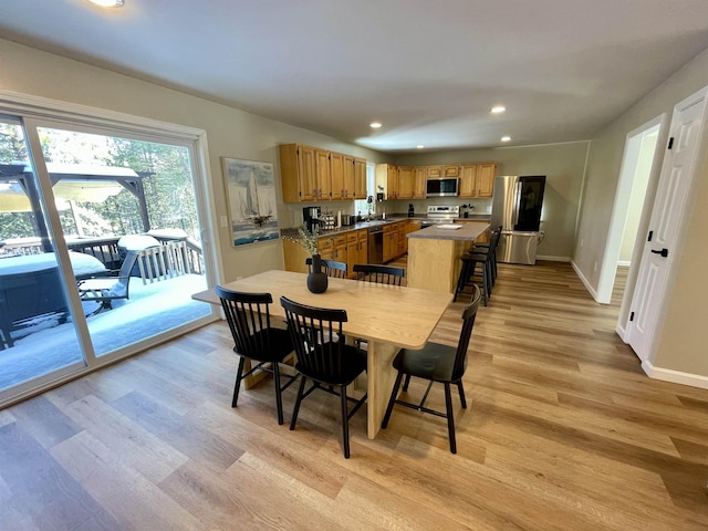 dining area with sink and light hardwood / wood-style floors