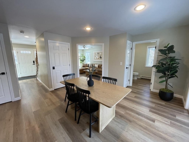 dining space featuring a baseboard heating unit and hardwood / wood-style floors