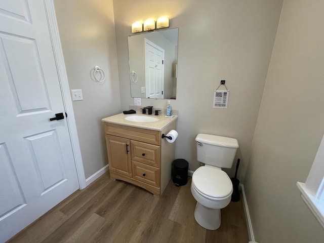 bathroom with vanity, wood-type flooring, and toilet