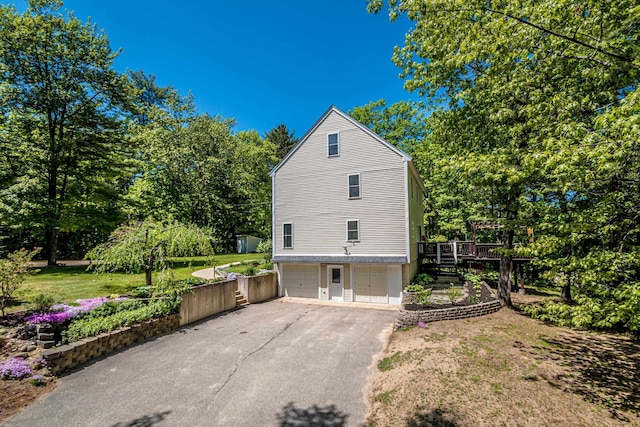 view of property exterior featuring a wooden deck and a garage