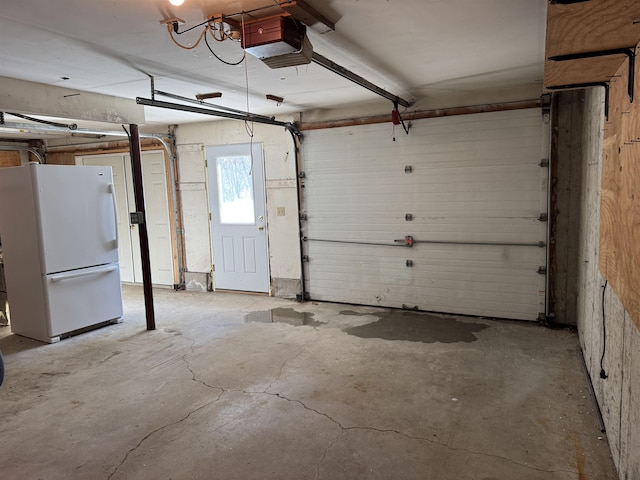 garage featuring white refrigerator and a garage door opener