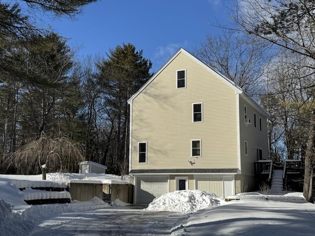 view of snowy exterior featuring a garage