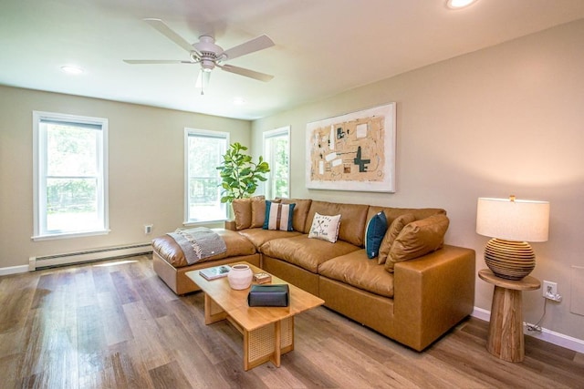 living room with ceiling fan, wood-type flooring, and a baseboard heating unit