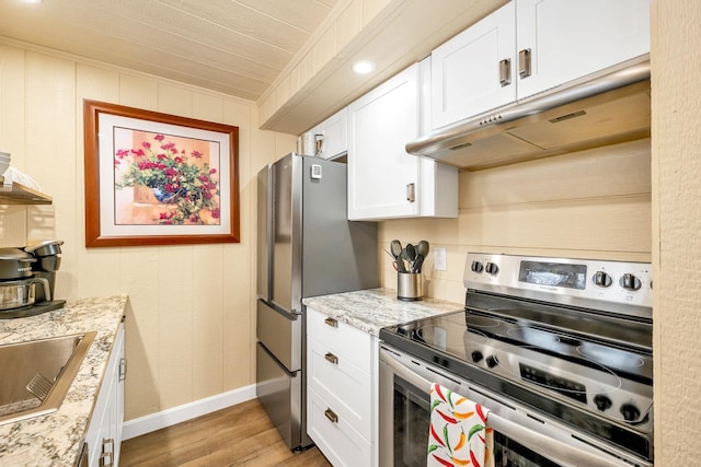 kitchen featuring sink, white cabinetry, light stone counters, light hardwood / wood-style flooring, and appliances with stainless steel finishes