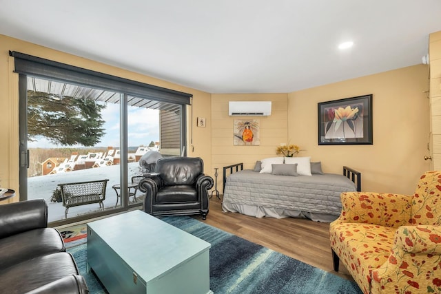 bedroom featuring hardwood / wood-style flooring, access to outside, and a wall mounted AC