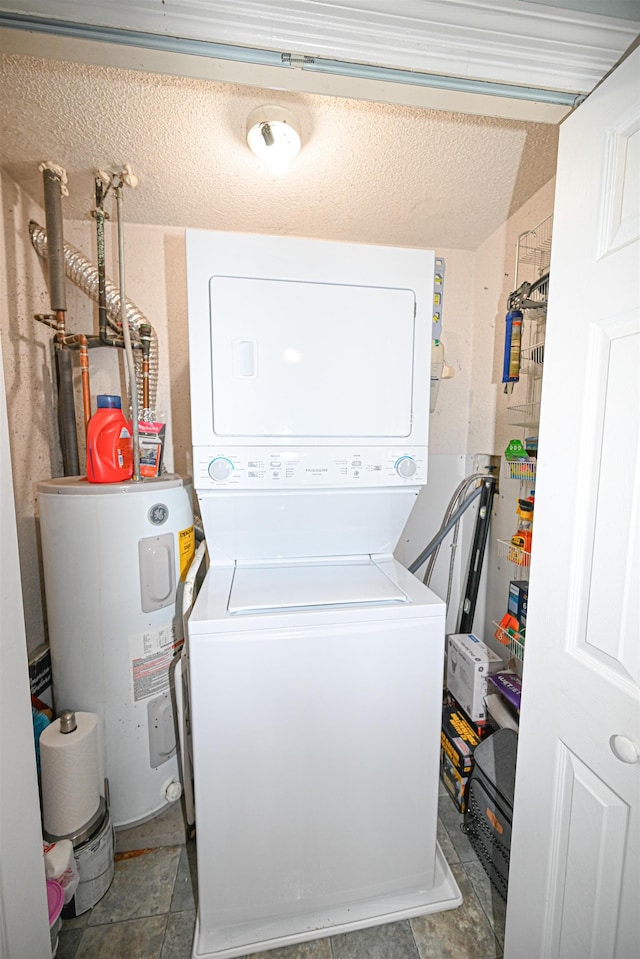 washroom with electric water heater, a textured ceiling, and stacked washer / dryer