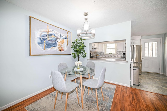 dining room featuring light hardwood / wood-style flooring and a textured ceiling