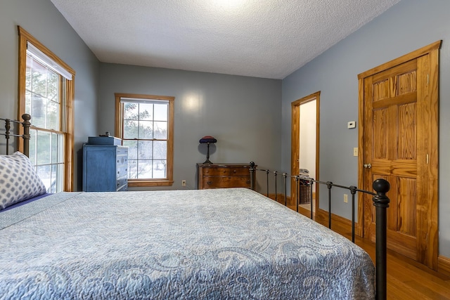 bedroom with wood-type flooring and a textured ceiling