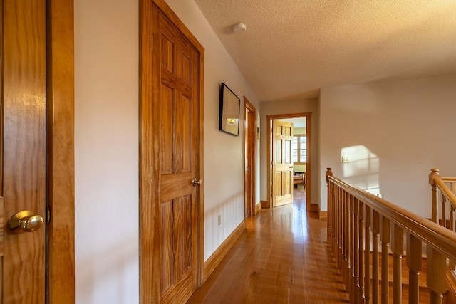 hall featuring wood-type flooring and a textured ceiling