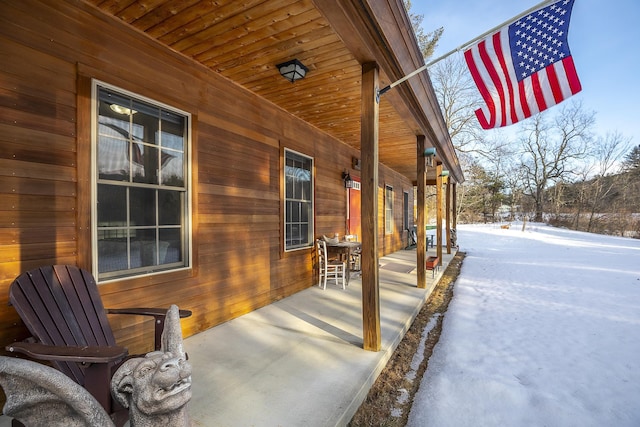 snow covered patio featuring a porch