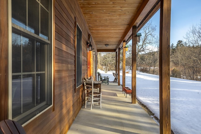 snow covered patio featuring a porch