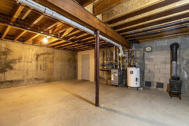 basement featuring water heater and a wood stove