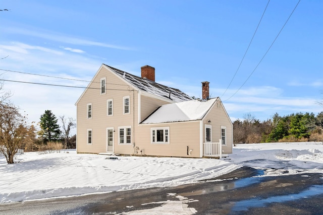 view of snow covered back of property