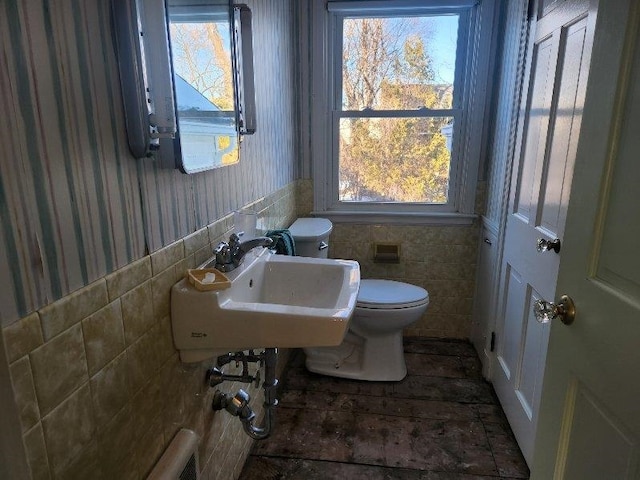 bathroom with tile walls, sink, and toilet