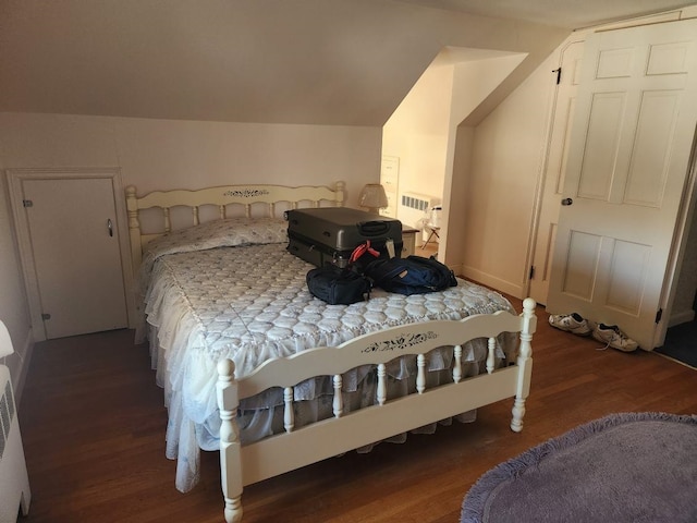 bedroom featuring lofted ceiling and dark hardwood / wood-style floors