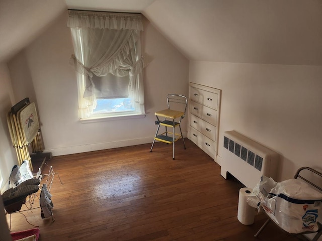 bonus room with radiator, dark wood-type flooring, and vaulted ceiling