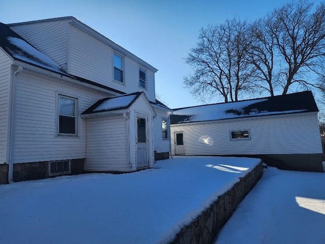 view of snow covered back of property