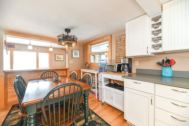 kitchen with pendant lighting, light wood-type flooring, and white cabinets