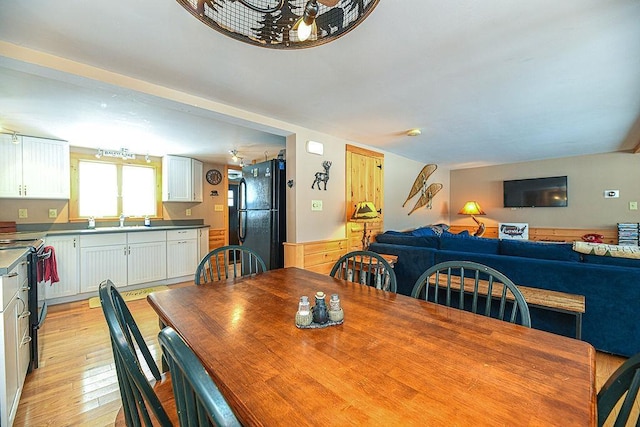 dining area with sink and light wood-type flooring