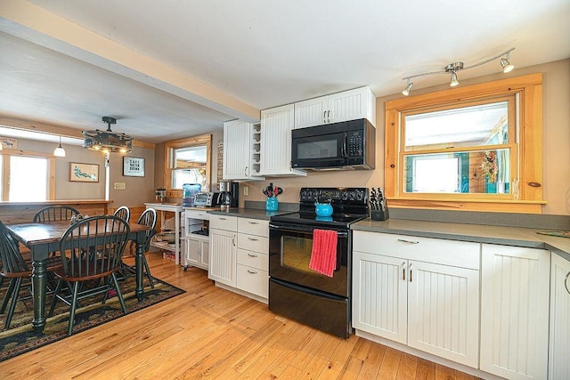 kitchen with white cabinetry, black appliances, light hardwood / wood-style floors, and a healthy amount of sunlight